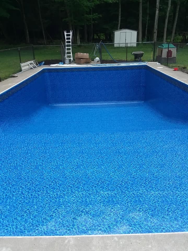 Pool after: new liner and deep blue water from the same viewpoint