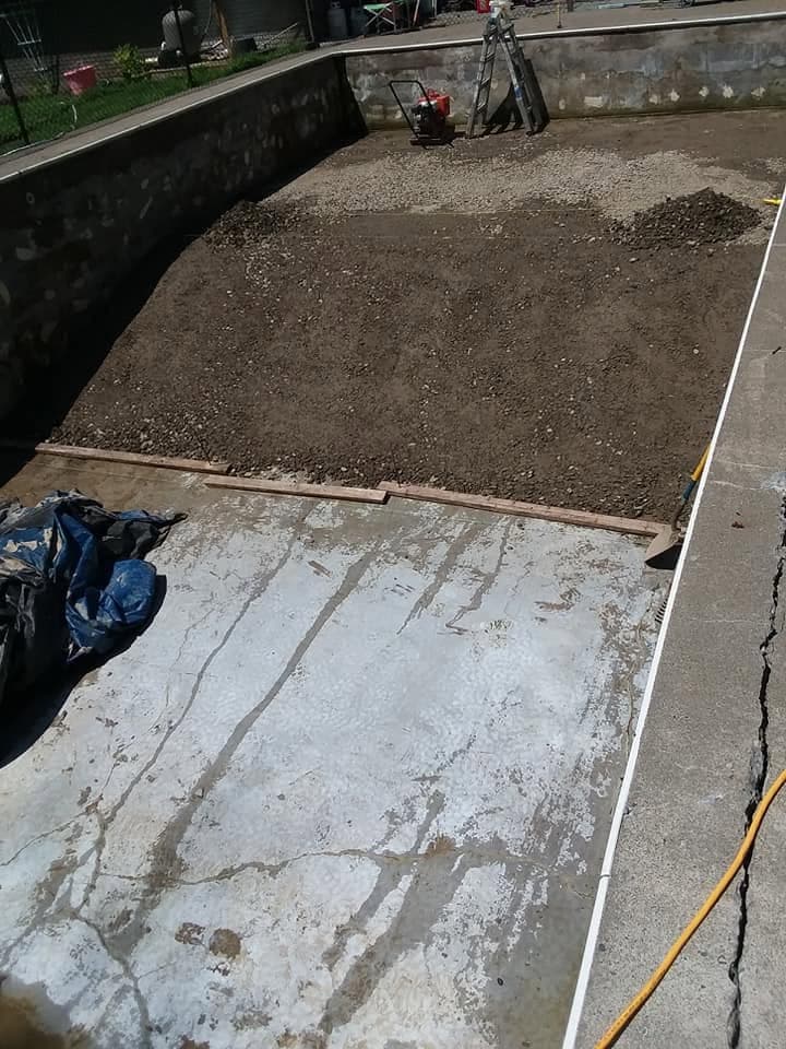 Fill dirt mounded in one end of the gutted pool to build up the new shallow end