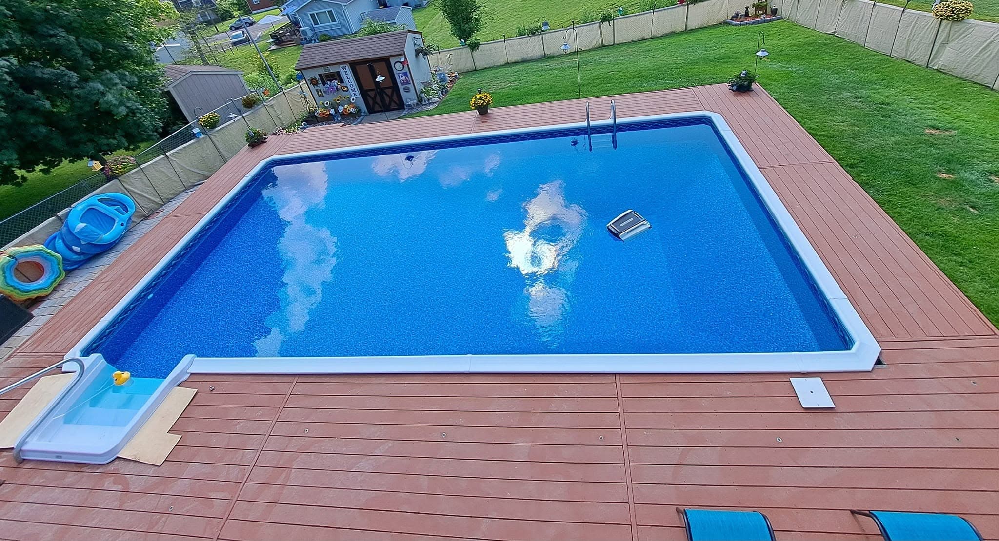 Pool after: new liner and sparkling blue water from the same deck viewpoint