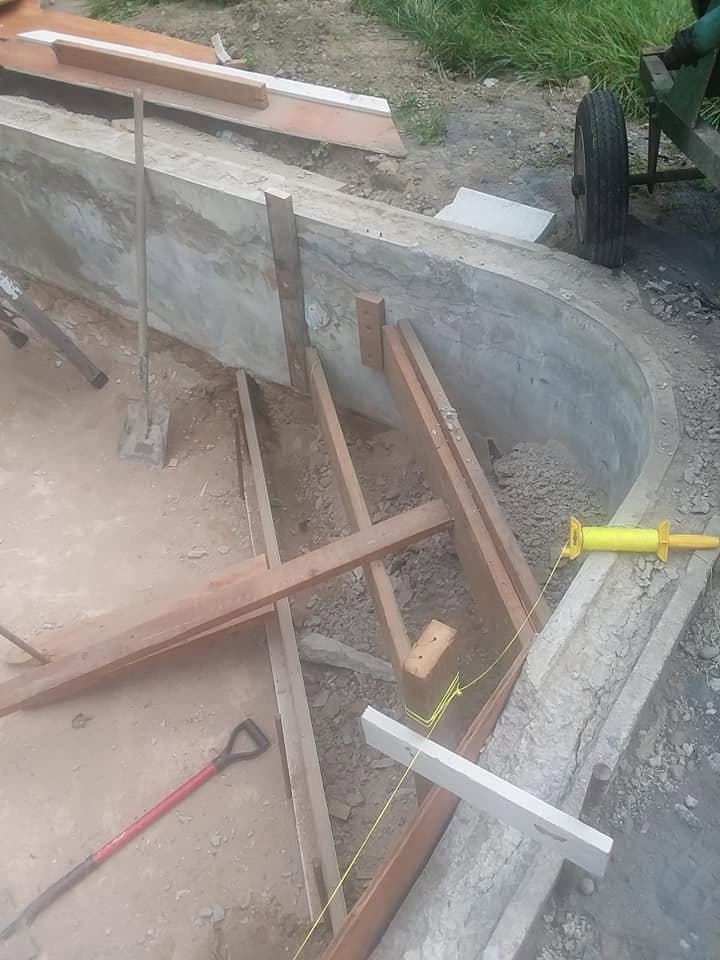 Wooden forms and string lines staked around the pool edge for the concrete pour