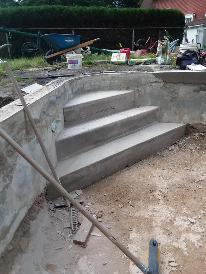 New concrete pool steps freshly poured in the gutted pool shell