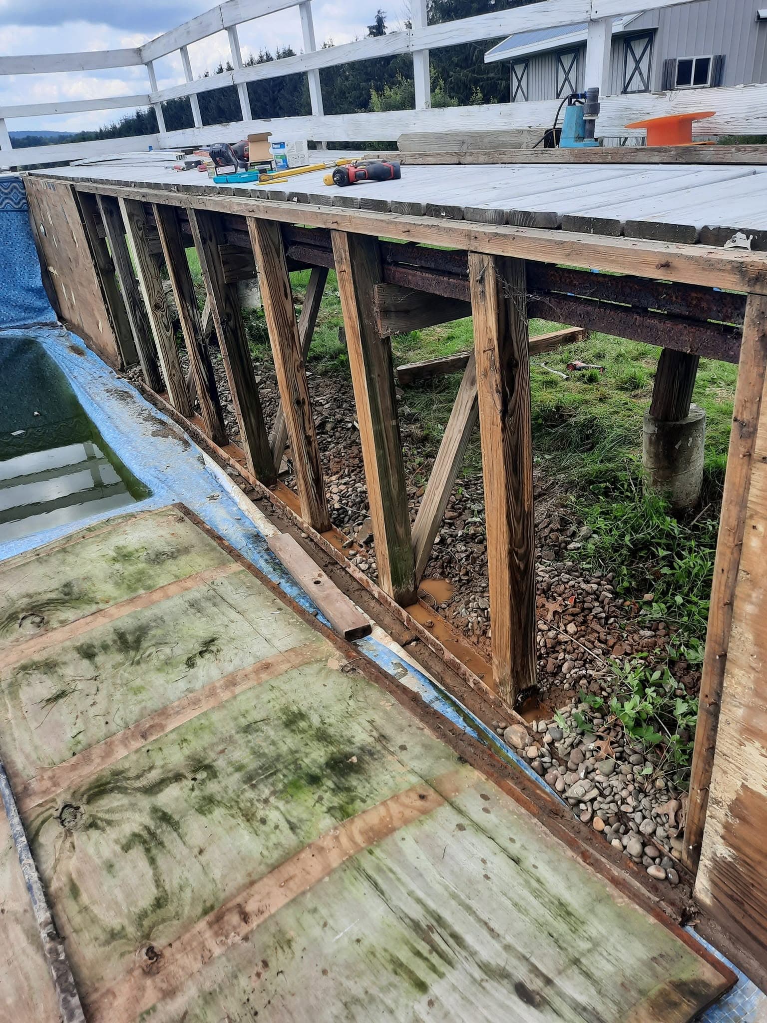 Deck boards removed exposing the pool wall framing during repair